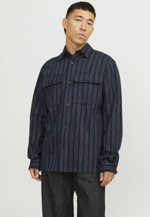 Navygestreept shirt van textuurstof, met een knoopsluiting aan de voorkant, twee borstzakken en lange mouwen met knoopmanchetten.