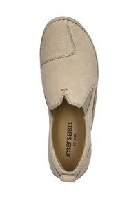Beżowe buty wsuwane z teksturowej skóry, z unikalnym wzorem przeszyć oraz elastycznymi bokami. Wnętrze wkładki pokazuje nazwę marki.