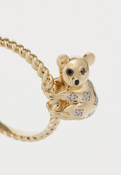 Χρυσό δαχτυλίδι με στριφτό σχέδιο που διαθέτει μοτίφ κοάλα στολισμένο με διάφανα πολύτιμα πετράδια, παρουσιάζοντας περίτεχνη λεπτομέρεια και γυαλιστερό φινίρισμα.