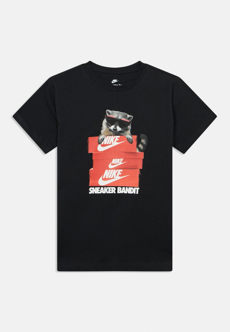 Μαύρη μπλούζα Nike με γραφικό ενός ρακούν που φοράει γυαλιά ηλίου και κρυφοκοιτάζει από στοιβαγμένα κόκκινα κουτιά παπουτσιών Nike με κείμενο "SNEAKER BANDIT."