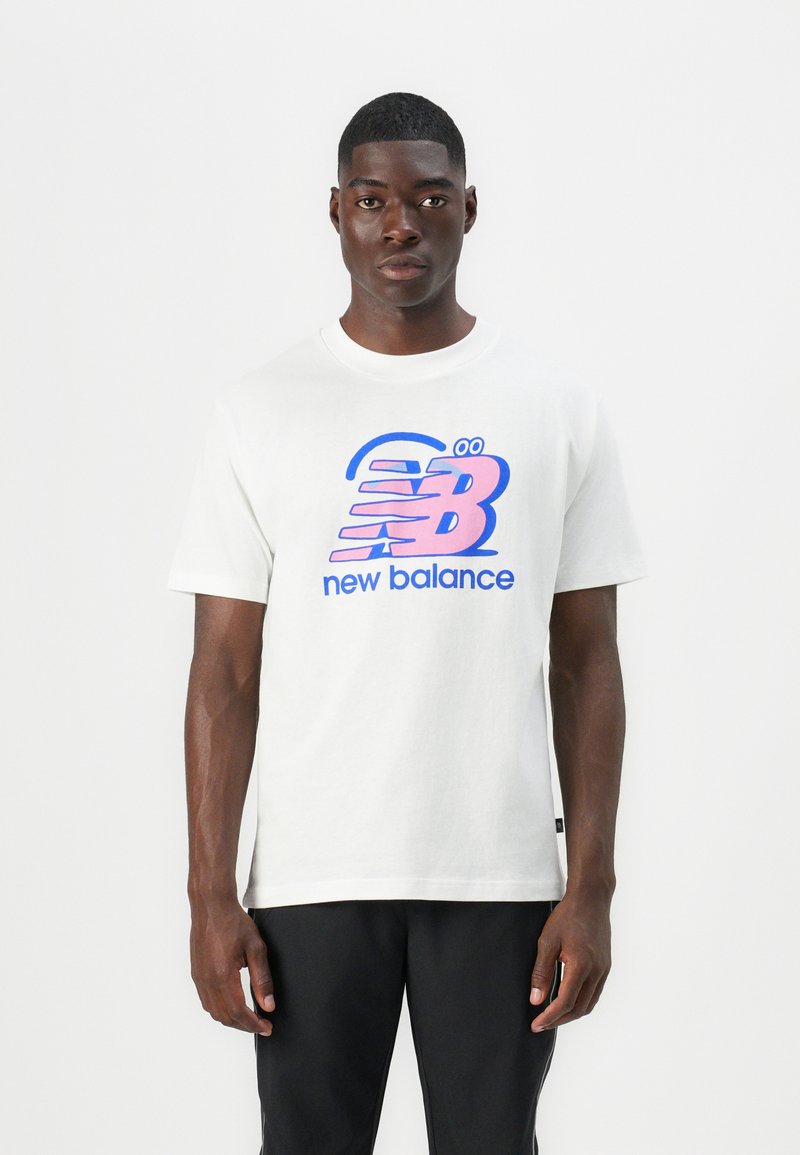 Hvid bomulds T-shirt med et stort pink og blåt "New Balance" logo, korte ærmer og en afslappet pasform med en rund halsudskæring.
