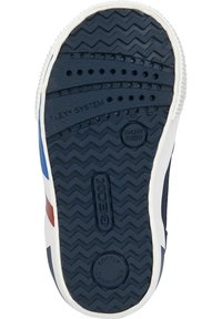 Suela de zapato de goma marítima con patrón de zigzag, que presenta orificios de ventilación, una marca en relieve y un borde blanco texturizado.
