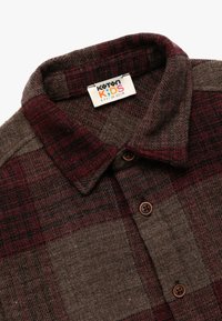 Bruin en bordeaux geruite flanellen shirt voor kinderen, met een puntige kraag, knoopsluiting aan de voorkant en een geweven textuur met een geweven label.