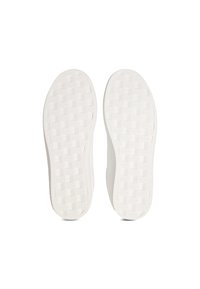 White rubber sneaker soles featuring a textured, checkered pattern with a slight curve at the heel, providing grip and stability.