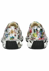 Zapatillas con un estampado floral, de diseño en blanco y negro con múltiples texturas, que presentan una suela flexible y acentos decorativos a los lados.
