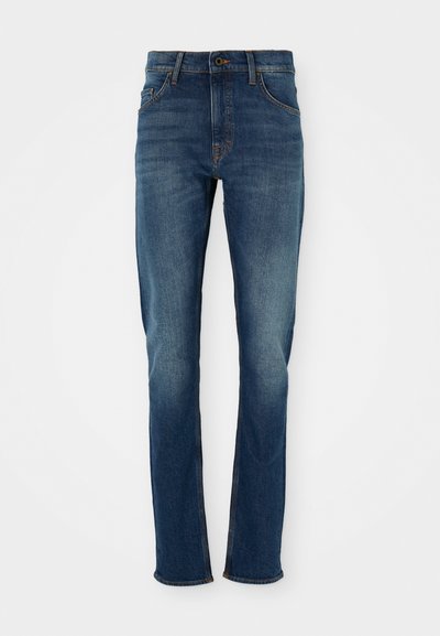 Jeans de ganga azul escuro com corte reto, cinco bolsos e desbotamento leve. Apresenta botão de latão e detalhes em costura laranja.
