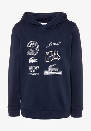 Felpa con cappuccio blu navy realizzata in morbido tessuto, con stampe grafiche e testo bianchi, incluso un logo di coccodrillo e vari design.