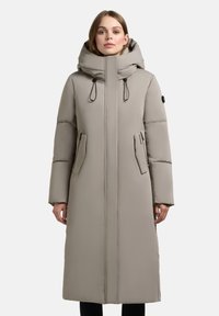 Lang beige pufferjakke med hætte, der har lynlås foran, sidelommer og justerbare snore. Glat tekstur, minimalistisk design.
