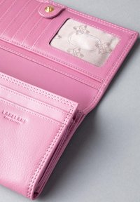 Pink leather wallet with a zipper, multiple card slots, and a transparent ID window. Features stitching detail and embossed logo.