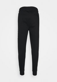 Zwarte sweatpants van zachte stof, met een tapered design en enkelboorden, plus een enkele achterzak. Subtiele branding aan de zijkant.