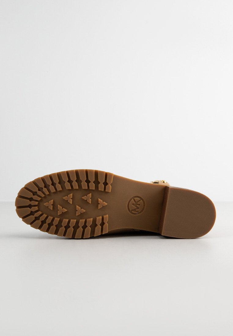 Gummisohle Stiefel mit einer strukturierten braunen Außensohle, die ein Profilmuster und ein sichtbares Logo aufweist. Minimale Akzente, robuste Konstruktion.