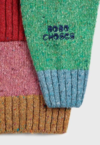 Mnohobarvový pletený sveter s zelenými, červenými, ružovými a modrými časťami. Má rebrovanú textúru a vyšívané logo "BOBO CHOSES" v námorníckej modrej.