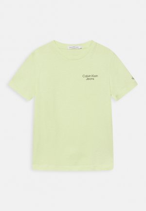 T-shirt vert clair à manches courtes avec "Calvin Klein Jeans" imprimé sur le côté gauche de la poitrine et un petit logo sur la manche gauche.