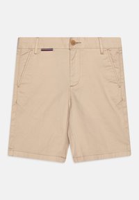 Pantaloni corti in cotone beige con chiusura a bottone, tasche frontali e un piccolo accento a righe multicolori vicino alla tasca. Tessuto liscio.