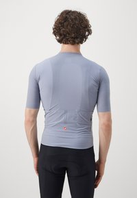 Maillot de cyclisme à manches courtes en gris clair, présentant un tissu texturé, des motifs subtils et une poche arrière avec un accent de logo.