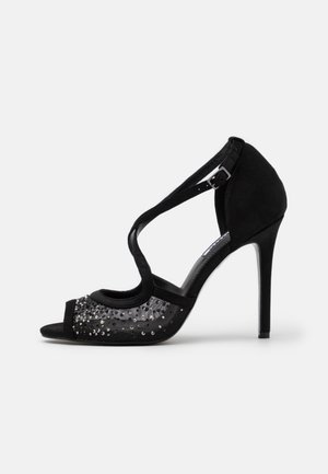 Sort højhælet sandal med åben tå, mesh og palietdetaljer foran samt ankelrem med spænde.