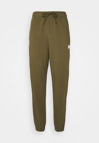 Oliwkowe dresy wykonane z miękkiego materiału, z elastycznym pasem w talii z regulowanym sznurkiem oraz ściągaczami przy kostkach.