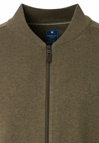 Braune gestrickte Zip-Jacke mit ribbeligem Kragen, versehen mit einem blauen Markenschild und einem kleinen Logo auf der linken Seite. Reißverschluss mit Lederzieher.