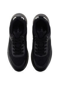 Sneaker neri con tomaia in tessuto trapuntato, dettagli lucidi, lacci piatti e punta arrotondata. Presentano un collare imbottito e suola testurizzata.