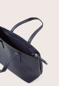 Borsa a tracolla in pelle blu navy con finitura texture, due manici e una tasca con zip all'interno. Design minimalista con forma rettangolare.