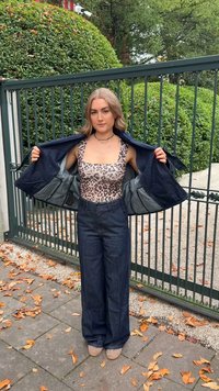 Traper jakna preko tijela s uzorkom leoparda, u kombinaciji s širokim tamnim trapericama. Zna�čajni detalji uključuju kvadratni izrez i svestran slojeviti stil.