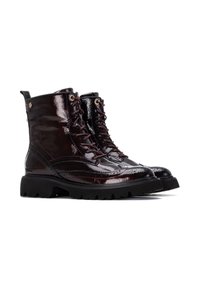 Botas de tobillo de charol burdeos con suela negra robusta, parte delantera con cordones y detalles de brogue a lo largo de los lados. Ojetes en tono dorado incluidos.