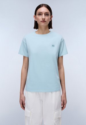 Lichtblauw katoenen t-shirt met korte mouwen en een ronde hals. Heeft een klein logo in de linkerbovenhoek. Zorgt voor een soepele textuur.