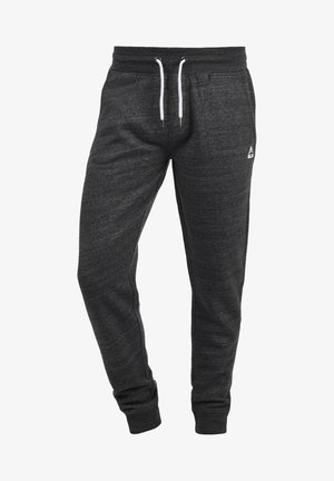 Grijze sweatpants van zacht materiaal, met een elastische tailleband met witte trekkoorden, zijzakken en taps toelopende boorden.