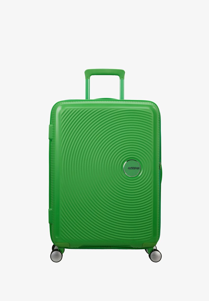 Green hard-shell suitcase with a textured wave pattern, extendable handle, and four spinner wheels for mobility. Features a logo detail.
