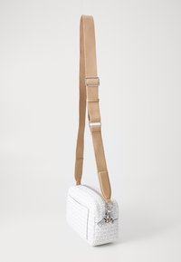 Borsa in tessuto bianco con un sottile motivo a logo, forma rettangolare, tracolla beige e hardware silver. Presenta una chiusura con zip e una tasca frontale.
