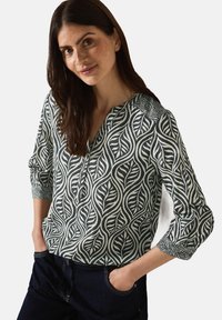 Groene en crèmekleurige blouse met knopen, voorzien van een bladerenpatroon, lange mouwen met opgerolde cuffs en een ontspannen pasvorm. Soepele textuur en zachte stof.