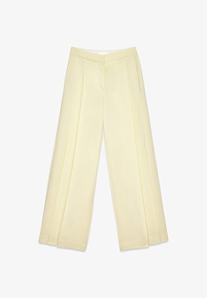 Kahvat kollased laiad püksid eespresside ja sileda tekstuuriga, puhtas viimistluses. Omavad sirget lõiget ja nähtavaid kinnitusi pole.