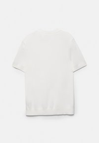 Preprost beli kratkoročni pleteni polo z ovratnikom in manšetami z rebrastim vzorcem, položen ravno od zadaj na belem ozadju.