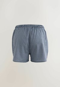 Blå- och vitrandiga shorts med elastisk midja, tillverkade av lätt material, med en avslappnad passform och sidofickor.