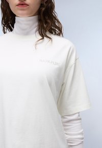 Witte korte mouwen t-shirt van katoen met een ronde hals. Bevat een reliëf "NAPAPIJRI" logo op de linkerkant van de borst. Glad van textuur.
