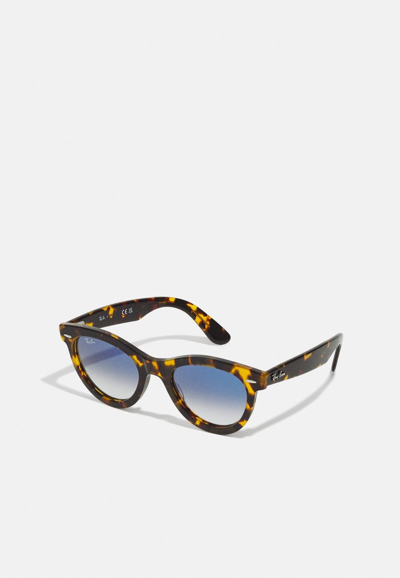 Ochelari de soare cu carapace de broască țestoasă, forma cat-eye, lentile gradient de culoare albastră și brandul Ray-Ban pe brasă. Materialul este plastic lucios.