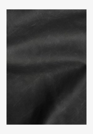 Tessuto nero con una consistenza liscia e opaca, caratterizzato da un motivo sottile. Il materiale appare resistente, con leggere pieghe che indicano flessibilità.