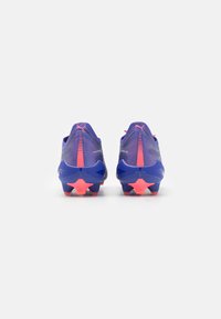 Bottes de football violettes avec un dessus texturé, des accents roses et des crampons en forme d'étoile. Présente un design élégant et un col bas.