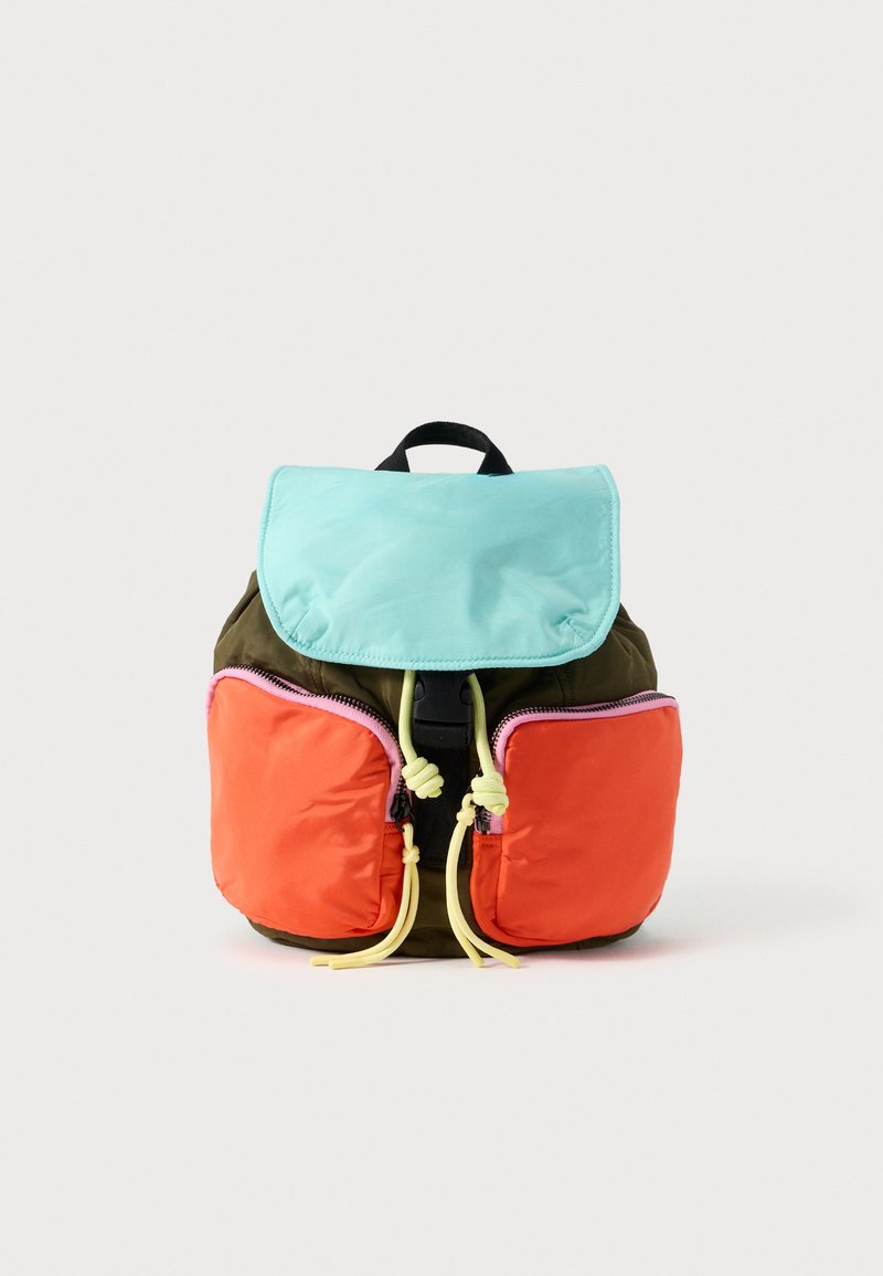 Sac à dos coloré avec un rabat supérieur turquoise, des poches avant orange et des accents jaunes. Fabriqué en tissu durable, il possède des fermetures éclair et une poignée.