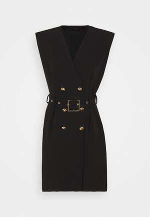 Černé šaty bez rukávů s dvojitým zapínáním a zlatými knoflíky a pásek s čtvercovou sponou, položeny na bílém pozadí.