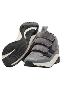 Szare buty sportowe z mieszanką tekstyliów i zamszu. Wyposażone w rzepy, gumową podeszwę z teksturowanym wzorem oraz zaokrąglony nos.