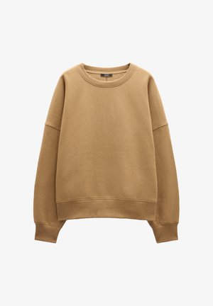 Beżowa bluza z okrągłym dekoltem, opadłymi ramionami oraz prążkowanymi mankietami i dołem. Miękka, gładka tekstura bez wzorów i akcentów.