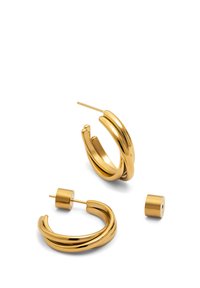 Boucles d'oreilles en or avec un design torsadé, l'une droite et l'autre légèrement inclinée, accompagnées d'une petite pièce arrière cylindrique.