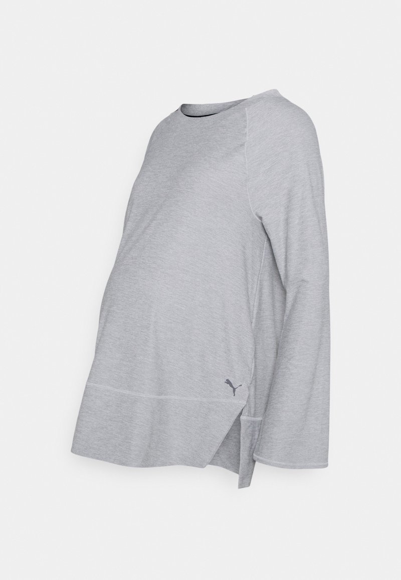 Šedé těhotenské tričko s dlouhým rukávem, kulatým výstřihem, raglánovými rukávy, bočním rozparkem a malým logem na spodním okraji. Vyrobeno z měkké látky.