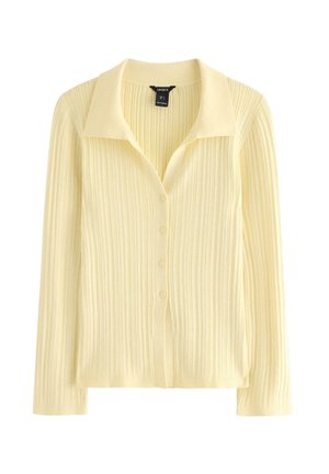 Gul ribstrikket cardigan med krave, lange ærmer og knaplukning foran. Fremstillet i blødt, letvægtsstof.