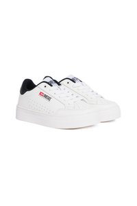 Tenis brancos com uma textura suave, apresentando um detalhe preto no calcanhar, um design perfurado nas laterais e um logo na língua.
