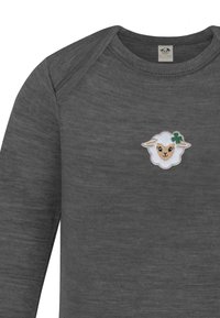 Graues Langarmoberteil aus strukturiertem Stoff, das vorne ein gesticktes Schafdesign mit einem grünen Kleeblattakzent zeigt.