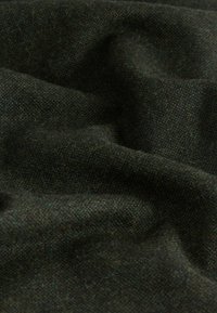 Țesătură verde închis cu o țesătură texturată, prezentând pete subtile de verde mai deschis. Moale și se așază lin, cu un luciu ușor.