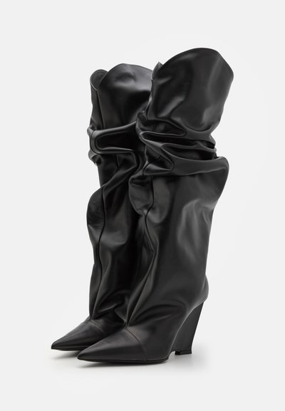 Botine negre de piele, până la genunchi, cu un design lejer, vârf ascuțit și tocul wedge. Textură netedă cu pliuri și cute notabile.