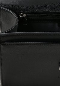 Borse in pelle nera con texture e chiusura con zip, dotata di tasche interne per l'organizzazione e un sottile motivo in rilievo.